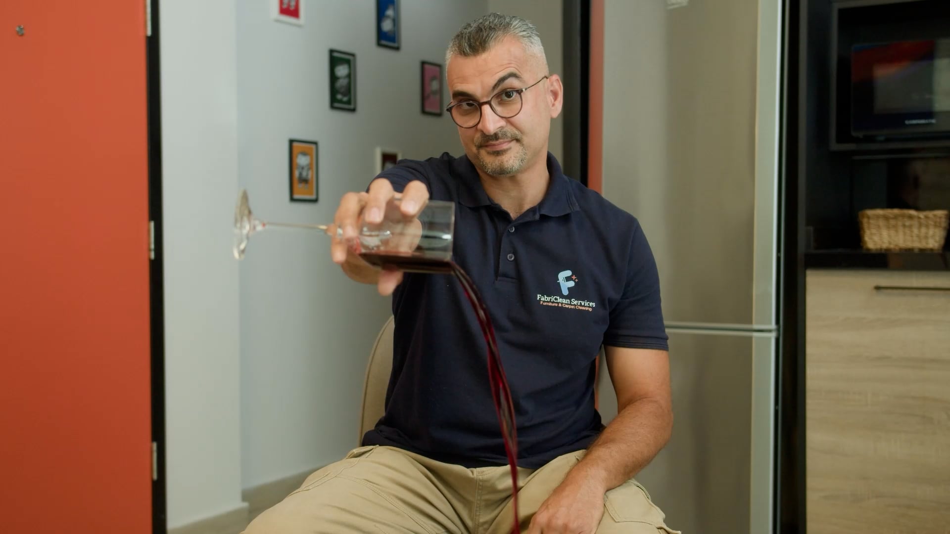 A creator tipping a glass of red liquid toward the floor during a lesson, a frame from the UNDP Self Independence Academy teaser