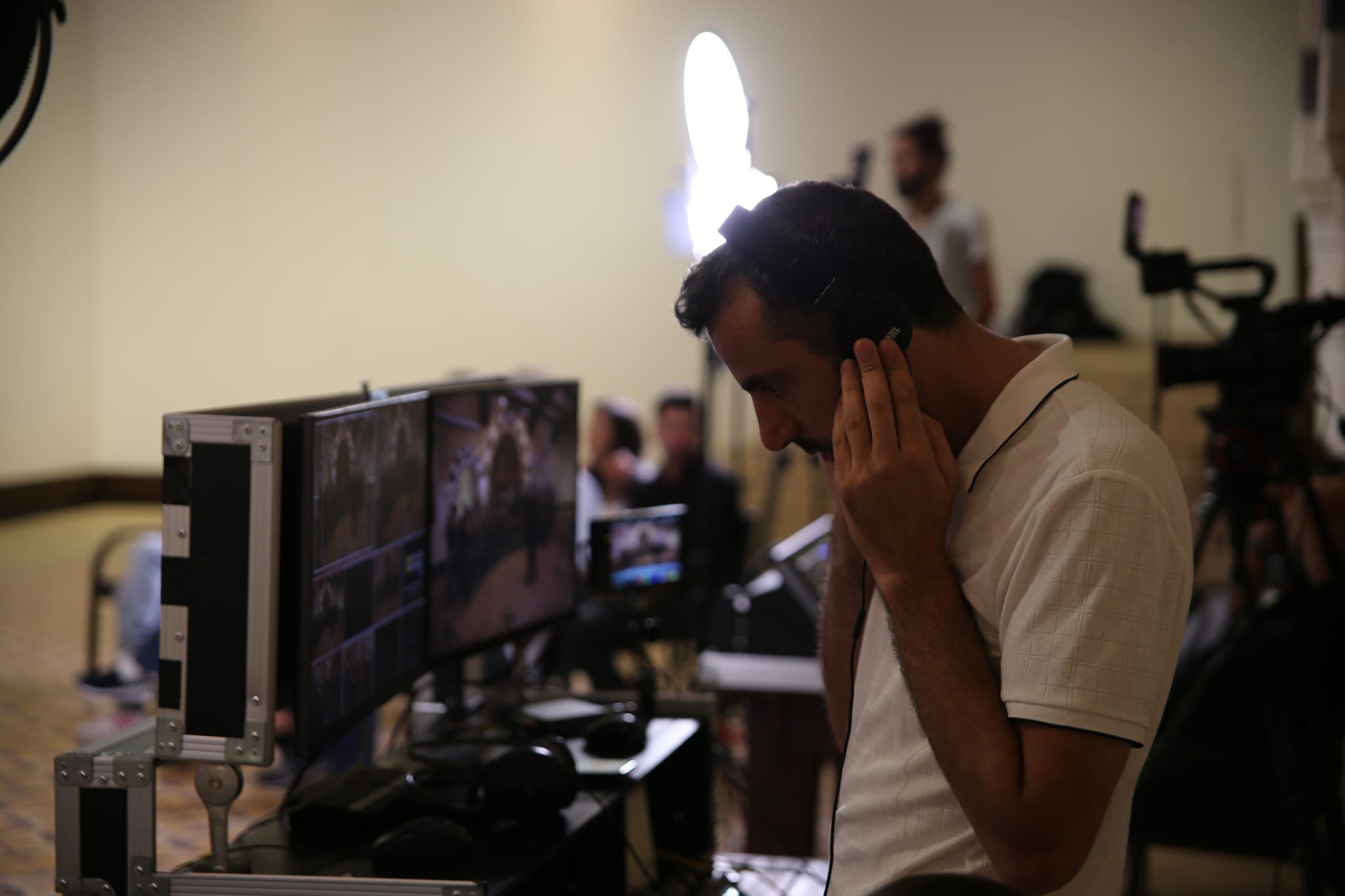 A Fine Line operator with headphones at the multiview monitors, cutting a live stream during an event