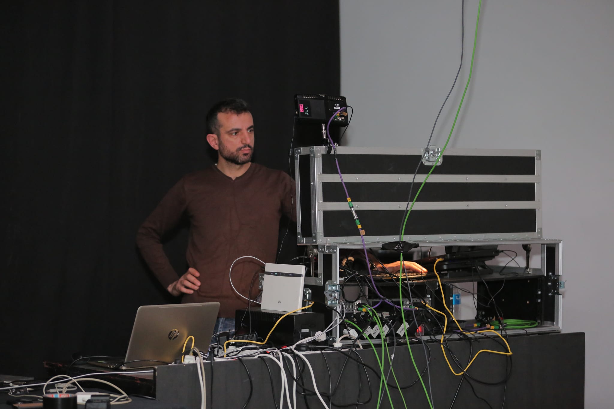 A Fine Line engineer at the streaming rack, with the connection and power cabling of a live setup