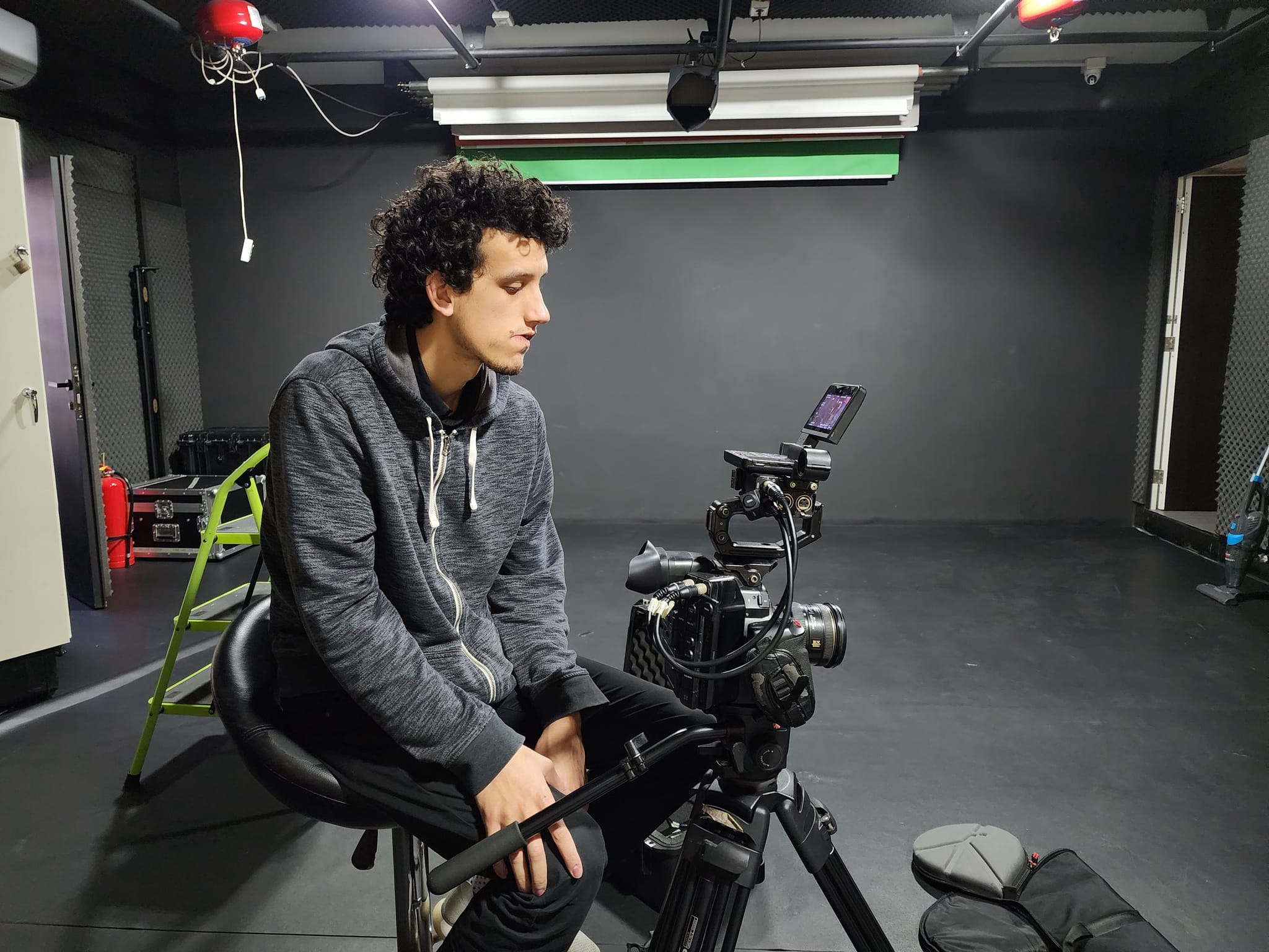 مصوّر يجلس إلى جانب الكاميرا في استوديو فاين لاين