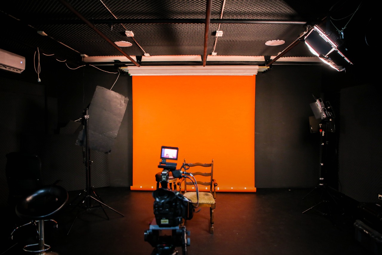 The Fine Line studio with an orange paper backdrop, lights and camera ready